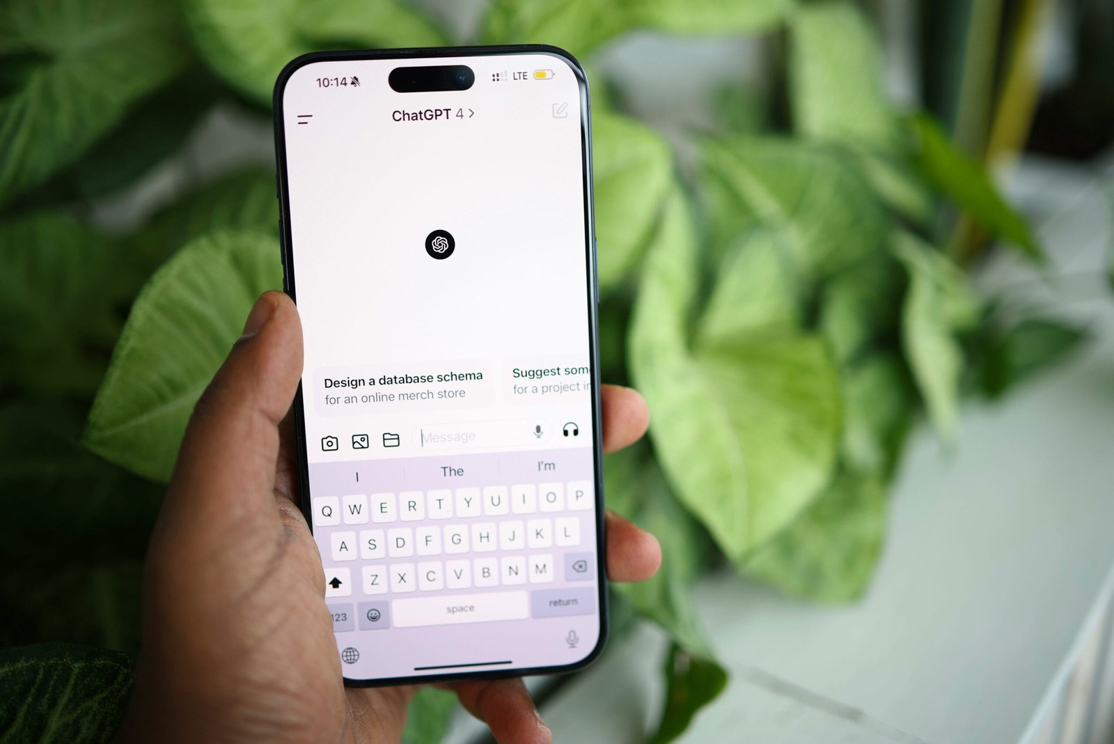 Person holding a phone displaying ChatGPT, illustrating ChatGPT vs Jasper vs Copy.ai comparison
